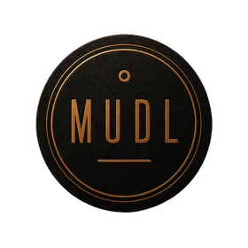 The Mudl mark: a matte black coaster stamped in copper foil, reading MUDL inside a double ring, with a dot above the U and a rule beneath.